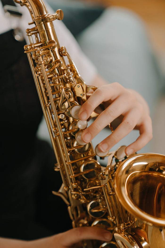 about-us-01 Close-up of a child playing a saxophone, highlighting musical details.